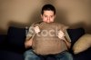 10201494-man-bites-pillow-in-fear-while-watching-tv.jpg