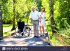 old-man-trying-to-walk-with-crutches-and-young-female-medical-assistant-JDBCNW.jpg